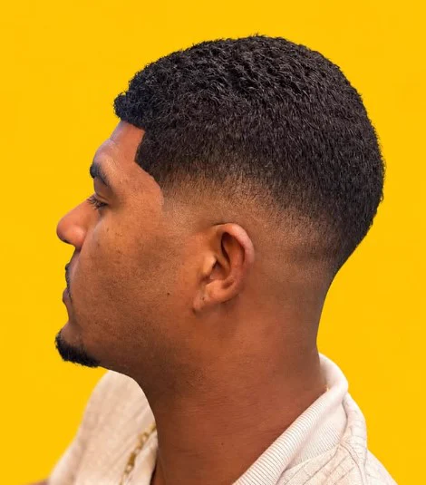 Cliente de perfil com corte baixo e degradê alto na Tesoura Barbearia